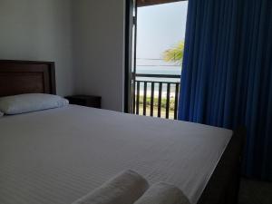a bedroom with a bed and a large window at Horizon Palace - Kabalana in Ahangama