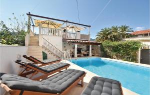 a swimming pool with two lounge chairs and a house at Nice Home In Jelsa With 3 Bedrooms, Private Swimming Pool And Outdoor Swimming Pool in Jelsa