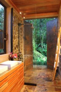 a bathroom with a glass shower and a sink at Hamadryade Lodge in Puerto Misahuallí