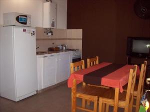 a kitchen with a white refrigerator and a table and chairs at Cabañas La Casa de Adriana in Merlo +38 photos