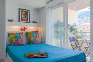 um quarto com uma cama azul com uma bandeja de comida em Villa Tobias em Nice