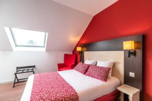 a hotel room with a bed with red walls at KYRIAD ROUEN NORD - Mont Saint Aignan in Mont-Saint-Aignan