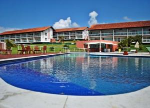 uma grande piscina em frente a um edifício em Flat no Villa Hípica - Gravatá em Gravatá