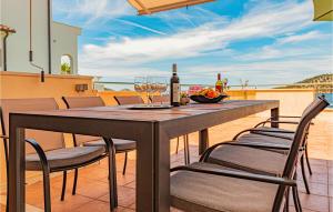 uma mesa com cadeiras e copos de vinho numa varanda em Awesome Home In Razanj With House Sea View em Razanj