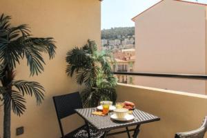 Un balcón con una mesa con comida. en Villa Tobias, en Niza