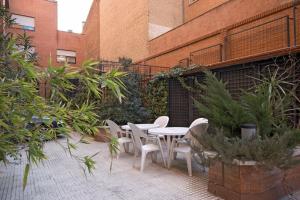 un patio con mesa y sillas frente a un edificio en Espahotel Plaza Basílica, en Madrid