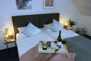 a bed with a tray with a bottle of wine and glasses at Hotel Baroko in Prague