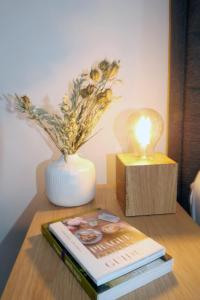a table with a book and a vase and a lamp at Hotel Baroko in Prague