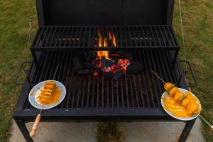 a grill with hot dogs and plates of food on it at SaffronStays Turquoise Maison, Karjat in Karjat
