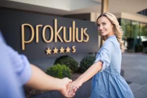a woman shaking hands in front of a pholis sign at Hotel Prokulus in Naturno