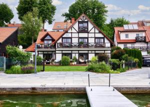 una casa con un estanque delante de ella en Willa nad jeziorem, en Mikołajki