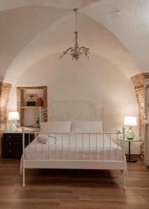 ein Schlafzimmer mit einem weißen Bett und einem Kronleuchter in der Unterkunft AI ROSONI in Venosa