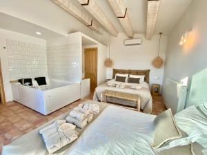 a bedroom with two beds and a bath tub at Mas de l'Aranyó - Eco Wellness Spa in Hostafranco