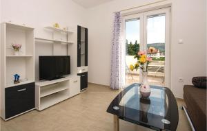 ein Wohnzimmer mit einer Vase aus Blumen auf einem Glastisch in der Unterkunft Beautiful Apartment In Poljica With Wifi in Poljica