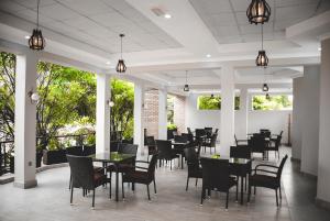 a restaurant with tables and chairs and windows at Dereva Hotel Rwamagana in Rwamagana