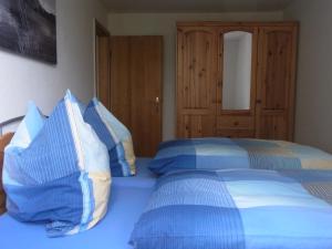 1 dormitorio con 2 camas y almohadas azules y blancas en Ferienhaus Appold, en Wernigerode