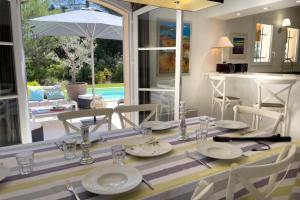 a dining room with a table and chairs and a kitchen at Ma villa en Provence villa de standing et piscine Domaine de Pont-Royal in Mallemort