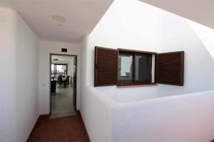 un couloir avec deux fenêtres sur un mur dans l'établissement Nuestra Casa apartamento con terraza azotea y piscina compartida, à San Juan de los Terreros