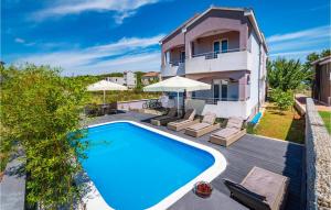 a swimming pool in front of a house at Stunning Apartment In Pasman With Heated Swimming Pool in Pašman