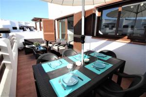 a table and chairs on a balcony with an umbrella at Casa Gecko apartamento para niños con piscina compartida in San Juan de los Terreros