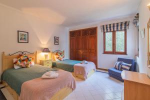 1 dormitorio con 2 camas, silla y ventana en Albufeira Salgados Beach 2 by Homing, en Albufeira