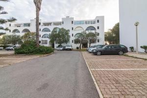 un gran edificio blanco con coches aparcados en un aparcamiento en Albufeira Salgados Beach 2 by Homing, en Albufeira