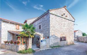 a stone building with a palm tree in front of it at Lovely Home In Svetvincenat With Wifi in Svetvinčenat