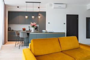 ein Wohnzimmer mit einem Sofa und einer Küche in der Unterkunft Liine apartment 5 in Pärnu