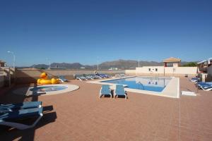 een zwembad met ligstoelen en een zwembad bij El Cid apartamento soleado vista panorámica al mar y piscina comunitaria in San Juan de los Terreros