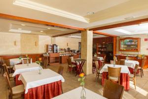 a restaurant with white tables and chairs and a counter at Hotel Noguera El Albir in Albir