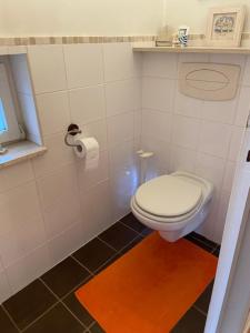 bagno con servizi igienici bianchi e pavimento piastrellato nero. di narcisses a Sint-Genesius-Rode