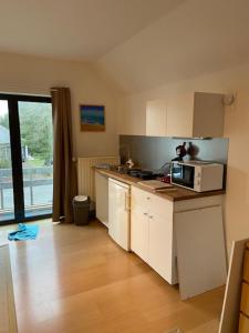 a kitchen with white cabinets and a microwave on a counter at narcisses in Sint-Genesius-Rode