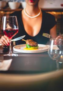 Hotel Lajta Park في موسونماجياروفار: امرأة تجلس على طاولة مع طبق من الطعام