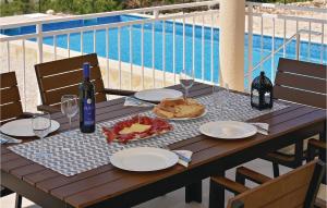 a wooden table with plates of food and a bottle of wine at Gorgeous Home In Krkovic With Outdoor Swimming Pool in Lađevci