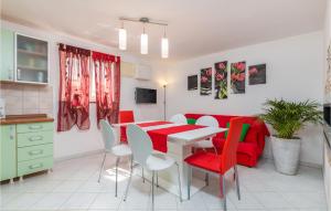 a kitchen and dining room with a table and red chairs at Amazing Home In Kastelir With 3 Bedrooms, Wifi And Outdoor Swimming Pool in Kaštelir