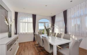 uma sala de jantar com uma mesa branca e cadeiras em Stunning Home In Podstrana With Wifi em Strožanac