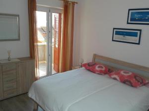 a bedroom with a bed with two pillows on it at Apartments Račić in Bol