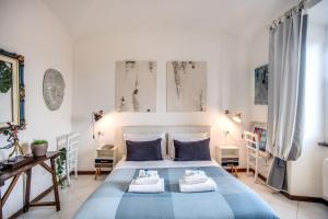 una camera da letto con un letto blu e asciugamani di TRASTEVERE - Stylish Good Vibes Apartment a Roma