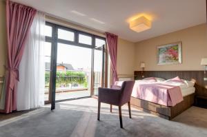 a bedroom with a bed and a large window at Hotel Figa in Plewiska