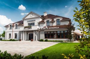a large white building with a sign that reads rico restaurant at Hotel Figa in Plewiska