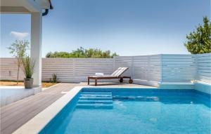 a swimming pool with a bench next to a fence at 2 Bedroom Nice Home In Betiga in Barbariga +22 photos