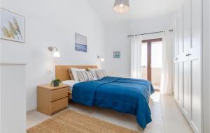 a white bedroom with a bed with a blue blanket at 2 Bedroom Nice Home In Betiga in Barbariga