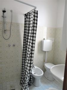 bagno con tenda per la doccia e servizi igienici di San Nichola's a Lido di Jesolo