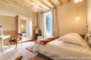 a bedroom with a bed and a desk and a window at Cosy a la campagne in Solsac