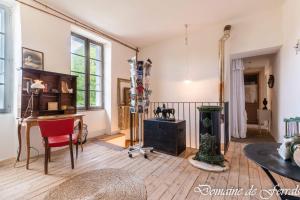 a living room with a table and a desk at Cosy a la campagne in Solsac