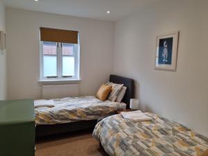 a bedroom with two beds and a window at Laston Mews in Ilfracombe