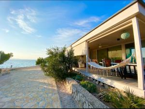 ein Haus am Strand mit Hängematte in der Unterkunft BUQEZ Villa 30 "Beachvilla Stella" mit SPA & Meerblick in Drage