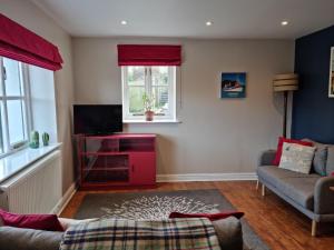 a living room with a couch and a tv at Laston Mews in Ilfracombe