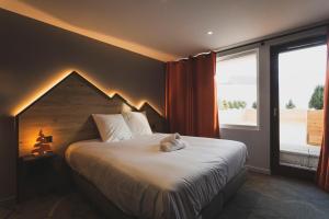 a bedroom with a large bed and a large window at Hotel Base Camp Lodge - Les 2 Alpes in Les Deux Alpes