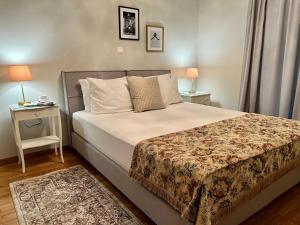 1 dormitorio con 1 cama y 1 mesa con 2 lámparas en Mrs Holiday Apartment en Atenas